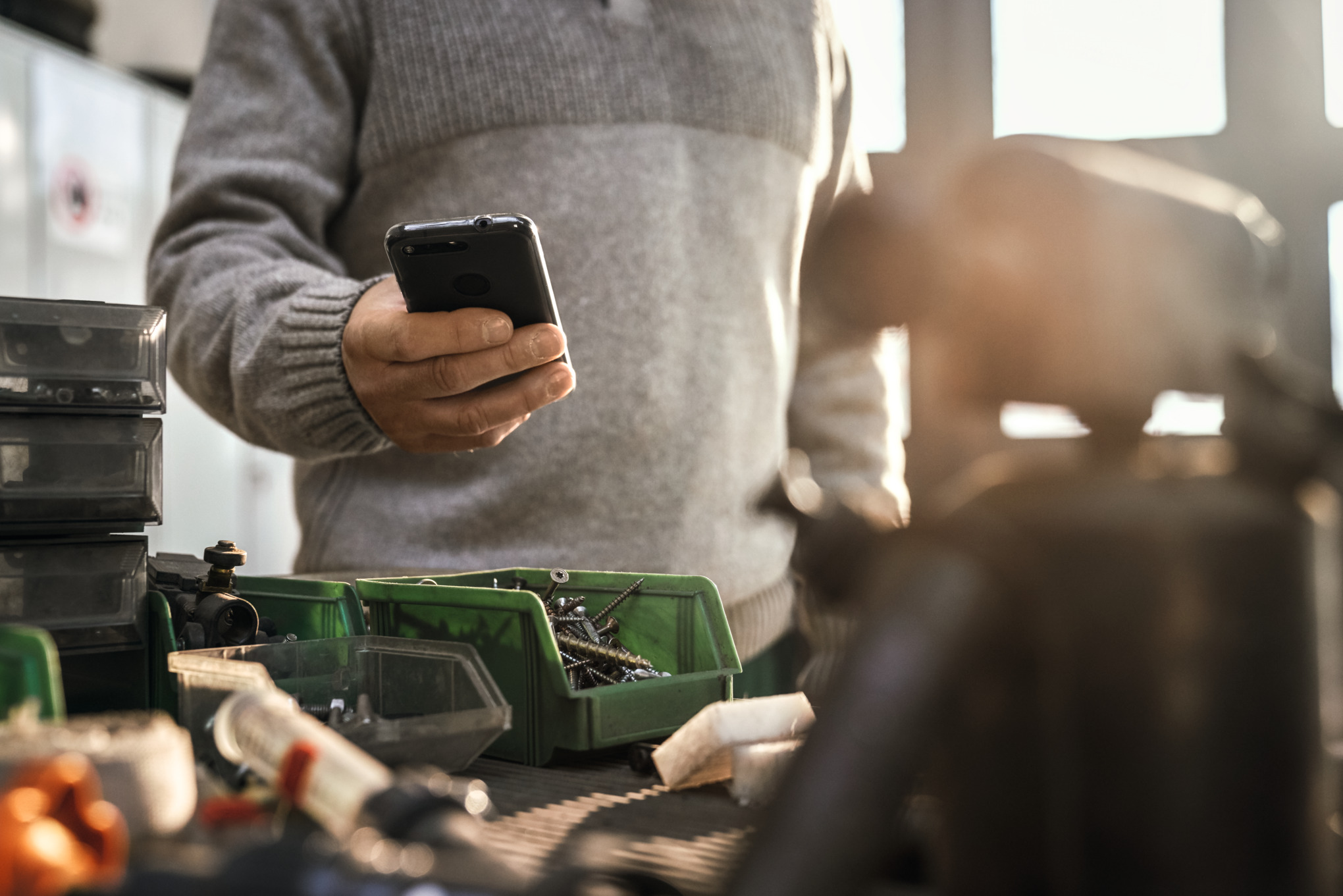 Uomo in officina con il telefono in mano