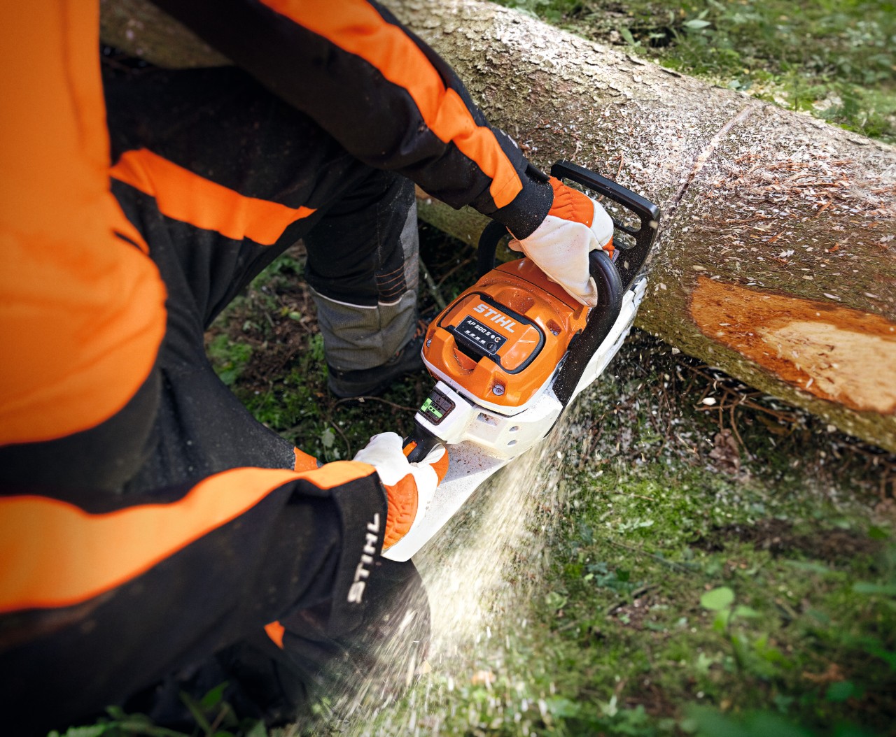 Primo piano di una persona che taglia un tronco d'albero utilizzando la motosega a batteria STIHL MSA 300