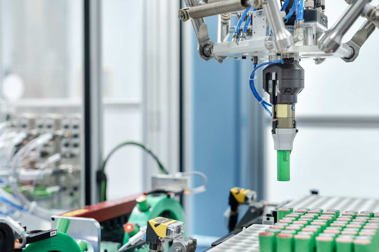 Un robot pick and place carica le celle delle batterie nei portacelle