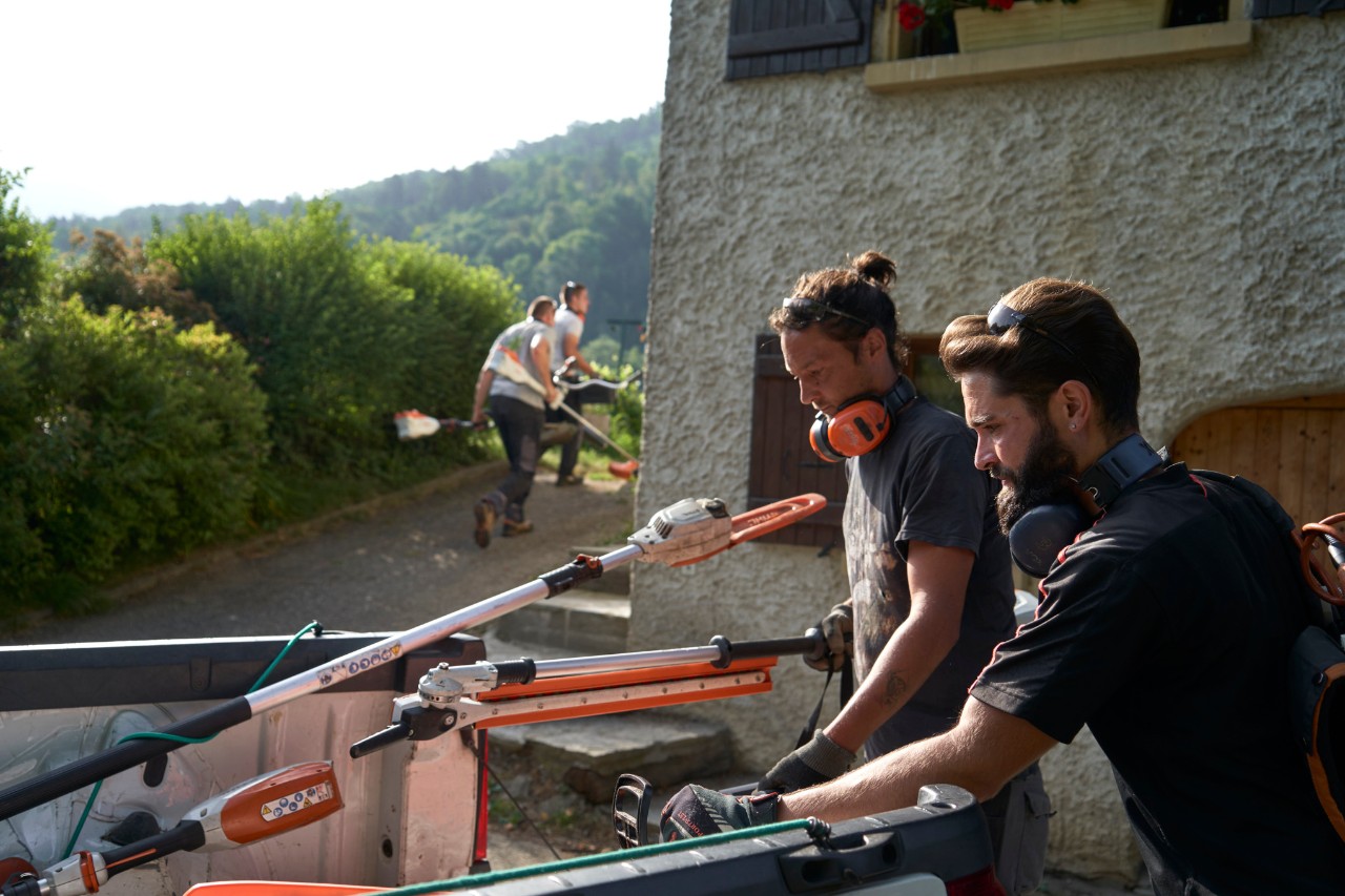 Julien Loquarelli, un paesaggista, scarica l'attrezzatura STIHL dal veicolo insieme ai suoi colleghi.